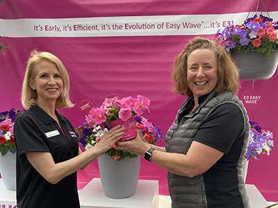 Photo is Sarah on the left receiving a Wave petunia pot from Claire Josephson on the right.