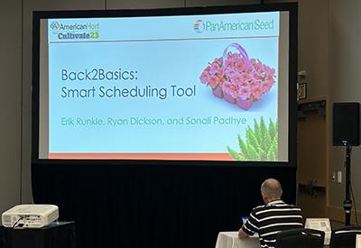 A presentation screen that has a slide titled Back2Basics: Smart Scheduling Tool