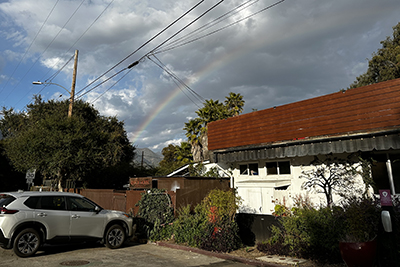 In front of the restaurant a colorful rainbow graces the sky.