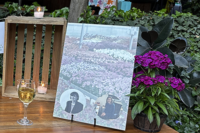 A congratulations to Anne Leventry - on a table sits a wine glass, candles and poster of her photos.