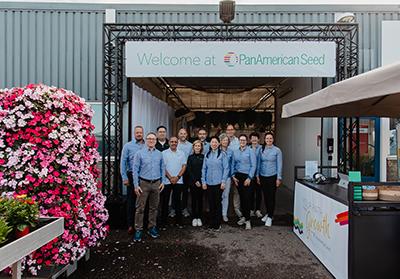 Group of people standing under a banner and surrounded by flowers