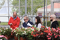 Group of people in a greenhouse filled with an assortment of colorful plants