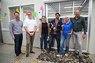 A group of smiling people in front of a grand opening