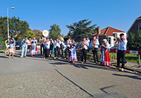A big choir with a band outside playing for race attendees