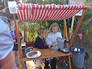 Little kids selling cookies at an outside dessert stand