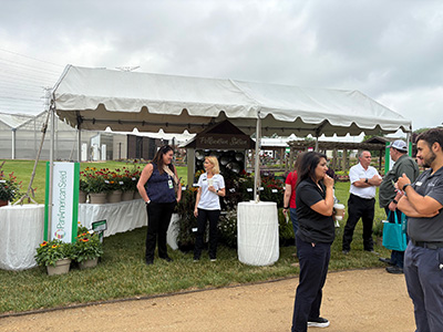 People under an event tent filled with flowers