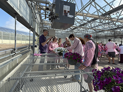 People in the greenhouse wearing pink aprons